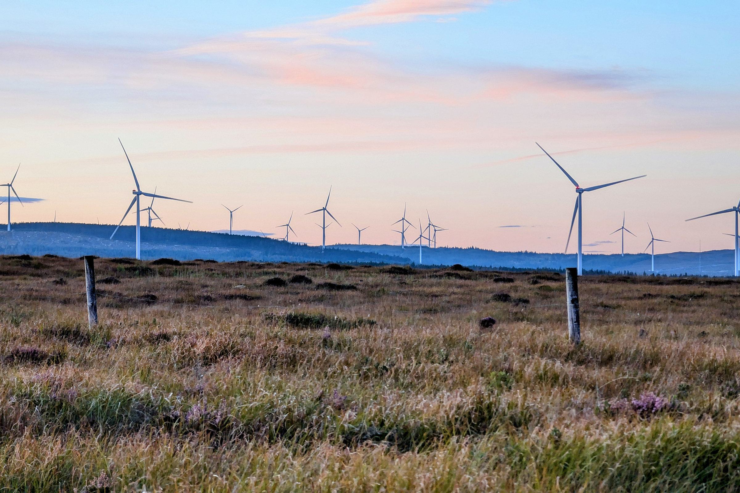 A UK onshore wind farm on open moorland at dusk