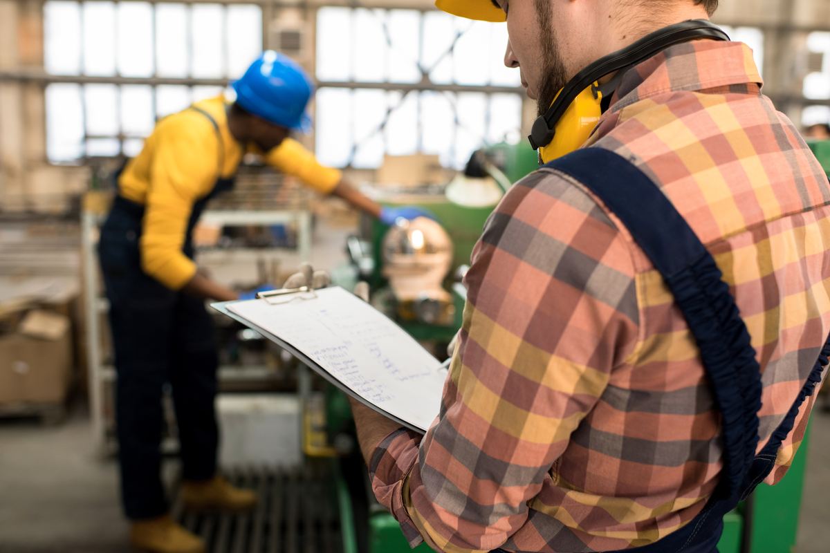 An inspector recording findings on a clipboard during a site audit